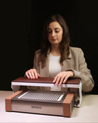 Woman using a SHEMAX device on a table with a dark background